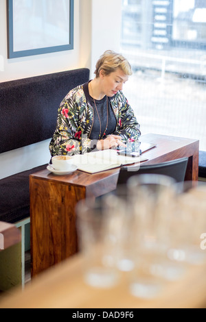 Woman using digital tablet in cafe