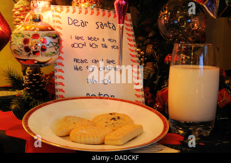 Cher Père Noël lettre avec du lait et des cookies en vertu de l'arbre de Noël. Banque D'Images
