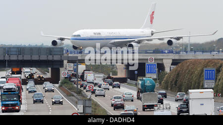 Un Airbus 340-300x d'Air China en passant sur un pont, manœuvres de l'autoroute A3 la position sur le chemin de la nouvelle piste vers le terminal de l'aéroport Rhin-Main à Francfort, Allemagne, 25 octobre 2011. La nouvelle piste a été construit à l'intérieur d'une période de deux ans et devrait augmenter la capacité de l'aéroport de 50  %. Peu avant le début de l'opération le nouveau sari Banque D'Images