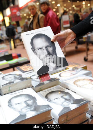 Une main tient la biographie du fondateur d'Apple, Steve Jobs, à la librairie Dussmann à Berlin, Allemagne, 27 octobre 2011. Le livre écrit par Walter Isaacson est disponible dès maintenant dans les magasins. Photo : BRITTA PEDERSEN Banque D'Images