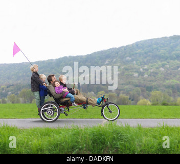 Family riding ensemble sur trois roues location Banque D'Images