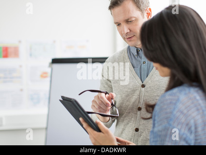 Homme mature et Mid adult woman using digital tablet in creative office Banque D'Images
