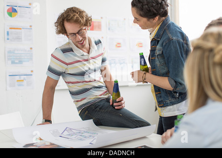 Office colleagues discussing plans créatifs sur 24