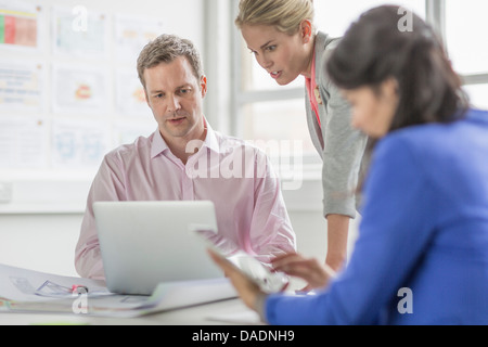 Des collègues d'affaires using laptop in meeting Banque D'Images