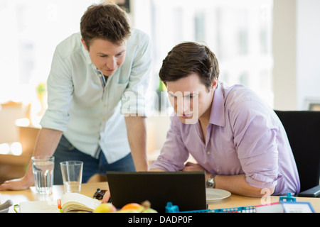 Les jeunes hommes working on laptop in creative office Banque D'Images