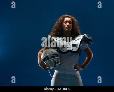 Portrait de femme joueur de football américain avec les épaulettes et le casque
