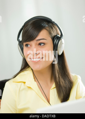 Young woman wearing headphones and smiling Banque D'Images