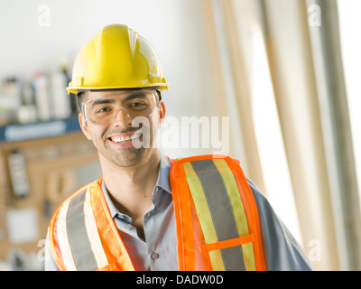 Mid adult construction worker smiling, portrait Banque D'Images