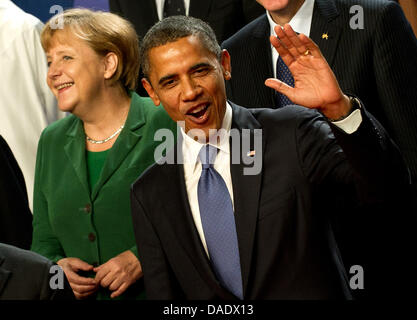 Le président américain Barack Obama (R) vagues aux photographes tandis que la Chancelière allemande, Angela Merkel, sourires au cours de la photo de groupe au sommet du G20 à Cannes, France, 03 novembre 2011. Le 03 et 04 novembre 2011, les chefs d'état des principales économies du monde (G20) se réunissent pour le sommet de cette année. Photo : GRIMM PAR LES PAIRS Banque D'Images