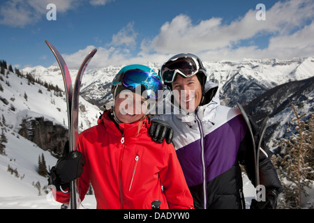 In et jeune femme de skiwear holding skis, portrait Banque D'Images