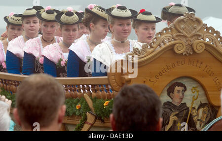 Les femmes en costumes s'asseoir dans un chariot décoré lors de la traditionnelle balade en Leonhardi Bad Toelz, Allemagne, 07 novembre 2011. Le tour est un événement en l'honneur du patron des animaux hébergés. Photo : PETER KNEFFEL Banque D'Images