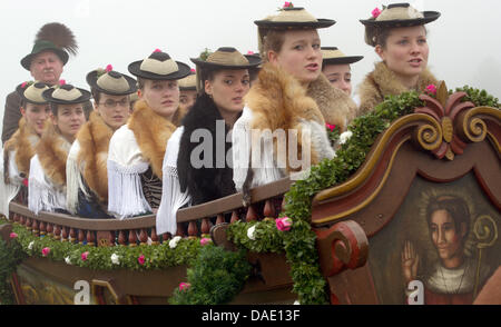 Les femmes en costumes s'asseoir dans un chariot décoré lors de la traditionnelle balade en Leonhardi Bad Toelz, Allemagne, 07 novembre 2011. Le tour est un événement en l'honneur du patron des animaux hébergés. Photo : PETER KNEFFEL Banque D'Images