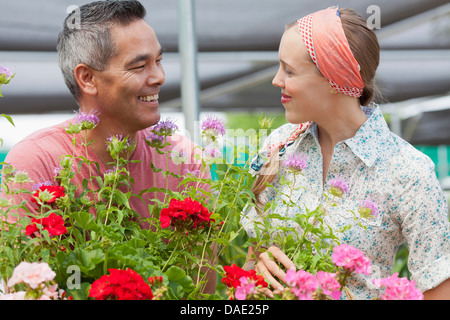 Homme mature et Mid adult woman shopping in garden centre, smiling Banque D'Images