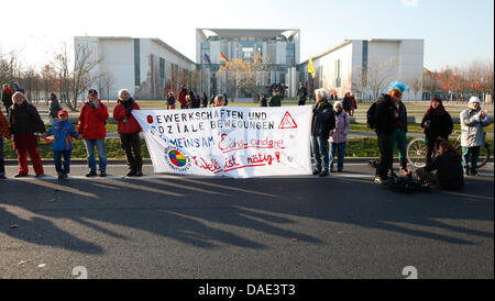 Les manifestants forment une chaîne humaine autour du quartier du gouvernement à Berlin, Allemagne, 12 novembre 2011. Dans l'arrière-plan la Chancellerie fédérale peuvent être vus. Le slogan de la manifestation organisée par Campact, Attac, l'Association allemande des amoureux de la nature et d'autres groupes est 'Ban' (les banques Banken in die Schranken). Une démonstration sous le même nom se déroule simultanément dans Frankfu Banque D'Images