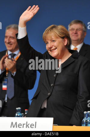 Présidente de la démocratie chrétienne et de la Chancelière allemande Angela Merkel vagues après son discours pendant la conférence du parti à Leipzig, Allemagne, 14 novembre 2011. Du 14 au 15 novembre 2011 la 24e conférence du parti fédéral des démocrates-chrétiens aura lieu à Leipzig. Photo : Bernd VON JUTRCZENKA Banque D'Images