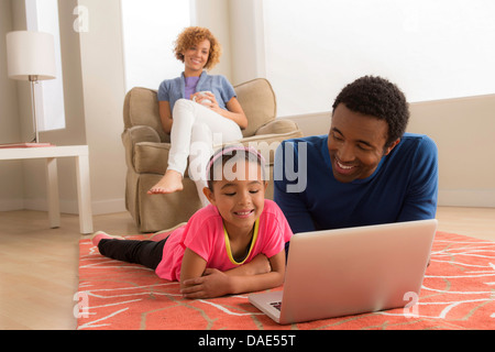 Père et fille on floor using laptop Banque D'Images
