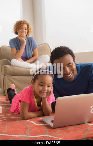 Père et fille on floor using laptop Banque D'Images