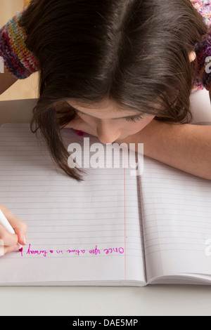 L'écriture de Fille en rose feutre dans l'ordinateur portable Banque D'Images