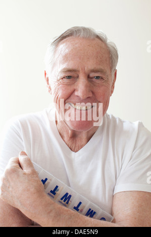 Senior man holding pill box Banque D'Images