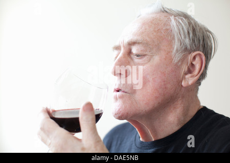 Senior man drinking red wine Banque D'Images