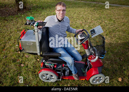 L'Eck Daniel études conduit un nouveau système intelligent de hauts-scooter développé à l'Institut d'informatique et robotique à Würzburg, Allemagne, 25 octobre 2011. Le scooter nommé véhicule assistance piéton est en mesure de conduire de façon autonome et éviter les obstacles. Photo : Daniel Karmann Banque D'Images