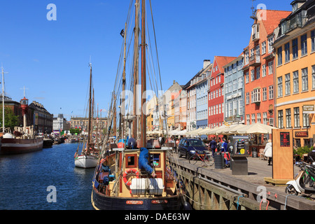 Vieux bateaux amarrés sur canal avec cafés et bâtiments colorés sur la 17ème siècle en bord de mer du port de Nyhavn Copenhague Danemark Banque D'Images