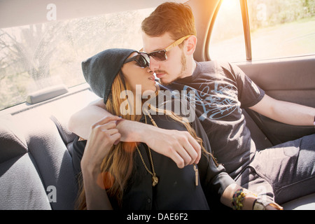 Couple sur la banquette arrière dans la voiture, en l'embrassant Banque D'Images