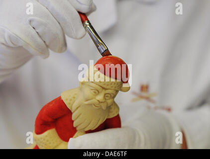 Les peintures d'un employé un Père Noël fabriqués à partir de mazipan avec colorant alimentaire à Niederegger à Luebeck, Allemagne, 09 novembre 2011. La production de Noël a été bat son plein à l'entreprise traditionnelle pendant quelques semaines. Il existe une demande pour des produits fabriqués à la main et pas tout à fait rempli ou par des machines. Photo : Angelika Warmuth Banque D'Images