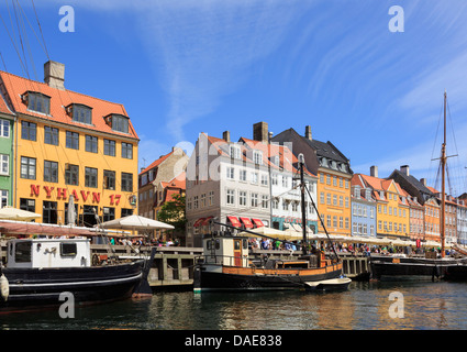 Vieux bateaux en bois amarré sur le canal par des bâtiments du xviie siècle sur le bord de mer en du port de Nyhavn, Copenhague, Danemark Banque D'Images