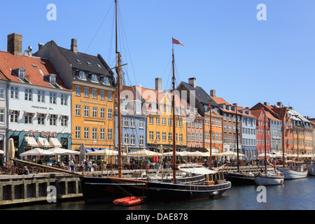 Vieux bateaux en bois amarré par canal quay avec des bâtiments du xviie siècle sur le bord de mer en du port de Nyhavn, Copenhague, Danemark Banque D'Images