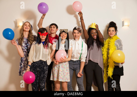 Les amis à une fête avec des ballons, studio shot Banque D'Images