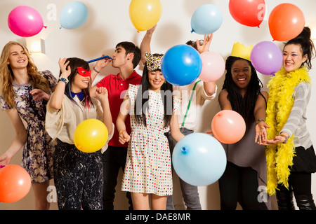 Les amis à une fête avec des ballons, studio shot Banque D'Images