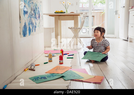 Young Woman sitting on floor avec dessins Banque D'Images