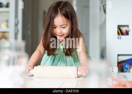 Jeune fille rouler une pâte sur le comptoir de la cuisine Banque D'Images