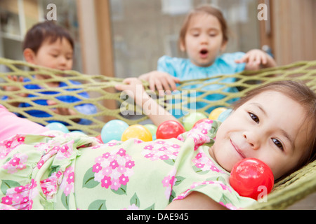 Portrait de jeune fille en hamac avec des balles de couleur Banque D'Images