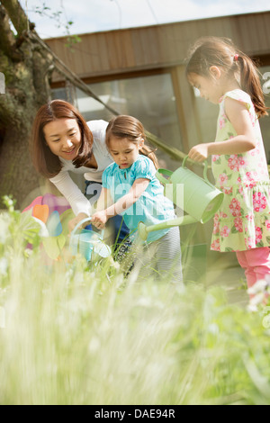 La mère et les filles d'arrosage jardin Banque D'Images