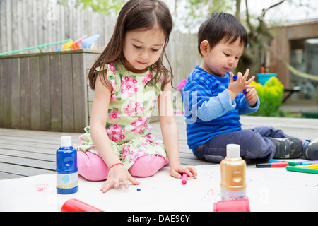 Les jeunes frère et sœur peinture et dessin dans le jardin Banque D'Images