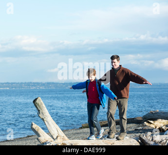 Père et fils marchant sur tronc d'arbre à l'autre Banque D'Images