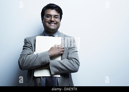 Studio portrait of businessman holding paperwork Banque D'Images