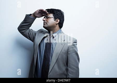 Studio portrait of businessman with hand yeux ombrage Banque D'Images