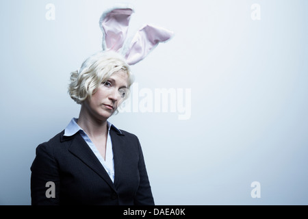 Studio portrait of blond businesswoman wearing Bunny Ears Banque D'Images