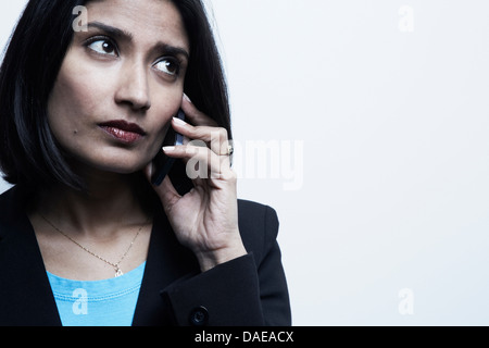 Studio portrait of businessman on cellphone Banque D'Images