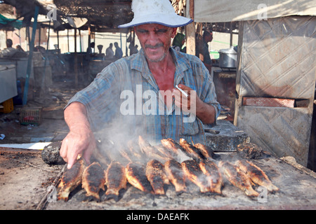 Homme plus vieux poissons cuisson du marché aux poissons, l'Egypte, Hurghada Banque D'Images