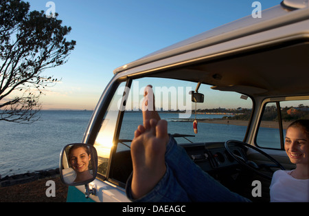 Jeune femme avec les pieds sur le camping-car window Banque D'Images