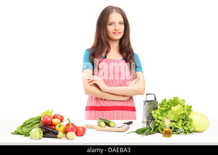 Jeune femme souriante avec tablier preparing salad Banque D'Images