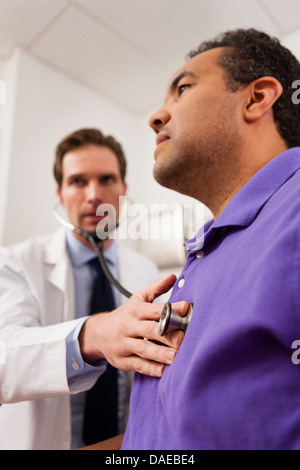 Young doctor with stethoscope on patient Banque D'Images