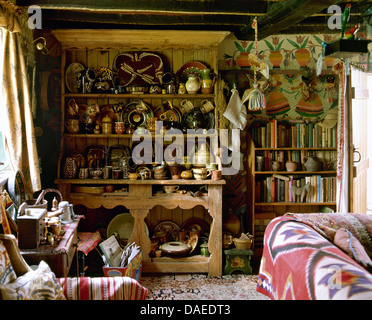 Des étagères couvertes de poterie sur grand buffet en pin salon encombré de country cottage Banque D'Images