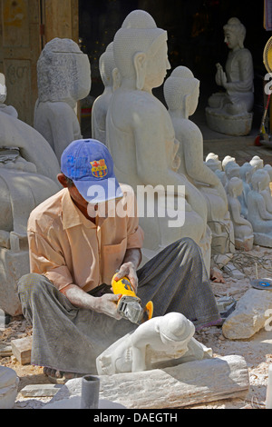 Homme avec un tailleur de travailler sur une sculpture de Bouddha, Birmanie, Mandalay Banque D'Images