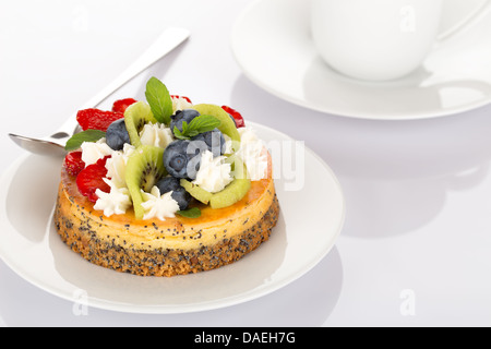 Gâteau au fromage à la fraise, myrtille, kiwi et crème sur plaque blanche. Banque D'Images