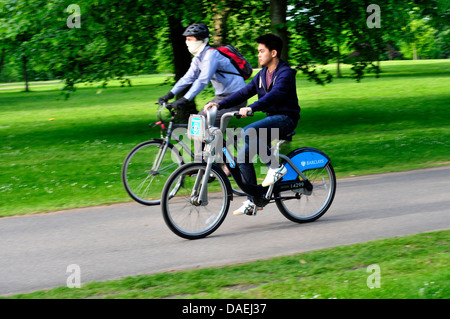 Deux hommes la bicyclette dans Kensington Gardens, London, UK Banque D'Images